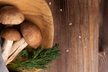wooden tray with porcini mushrooms on a wooden table. Ingredients before cooking.