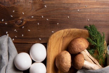 wooden tray with porcini mushrooms on a wooden table. Ingredients before cooking.