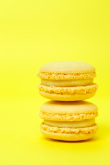 Two yellow macarons on yellow background