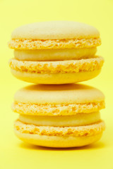 Two yellow macarons on yellow background