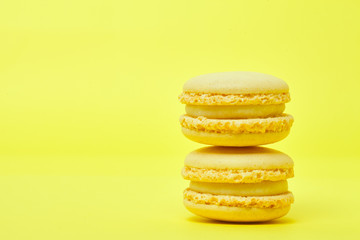 Two yellow macarons on yellow background