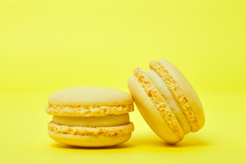Two yellow macarons on yellow background