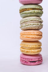 Column of colored macarons on white background