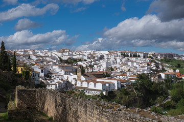 Fototapeta premium Spain, Andalusia, Ronda. Ronda is a classic example of a whitewashed hilltop village along the White Road, viewed here with the ruins of the old Roman stone wall of the city.