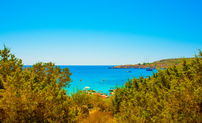 Fototapeta na wymiar blue sea with clear water, mountains, yachts and the beach on the panorama of Konnos Bay Cyprus