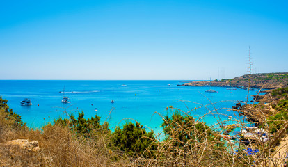  blue sea with clear water, mountains, yachts and the beach on the panorama of Konnos Bay Cyprus