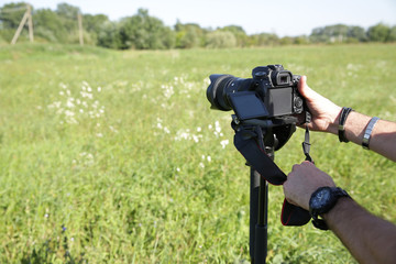 digital camera in hand photographer or videographer with monopod.