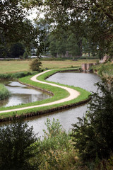 Fototapeta na wymiar typisch Holländische Landschaft mit Radweg und Kanal
