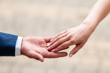 Bride and groom hands drawning to each other