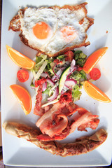 Spain, Balearic Islands, Mallorca, typical weekend breakfast of eggs, bacon, sausages and fruit and salad.