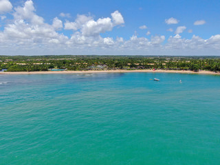 Fototapeta na wymiar Aerial view of tropical white sand beach, palm trees and turquoise clear sea water in Praia do Forte, Bahia, Brazil. Travel tropical destination in Brazil