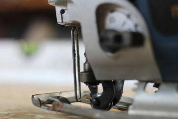 blue-silver electric jigsaw on the osb plate. The process of sawing OSB plywood