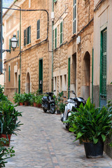 Fototapeta na wymiar Spain, Balearic Islands, Mallorca, Soller, historical Northwest Coast village town. Stone side alleyway. Motor scooters.