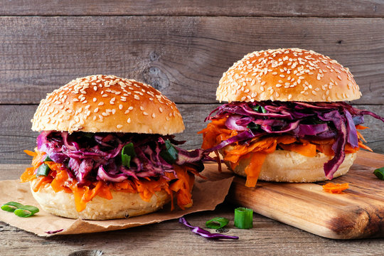 Pulled Carrot Meatless Burgers With Red Cabbage Slaw Against A Dark Wood Background. Healthy Eating, Plant-based Meat Substitute Concept.