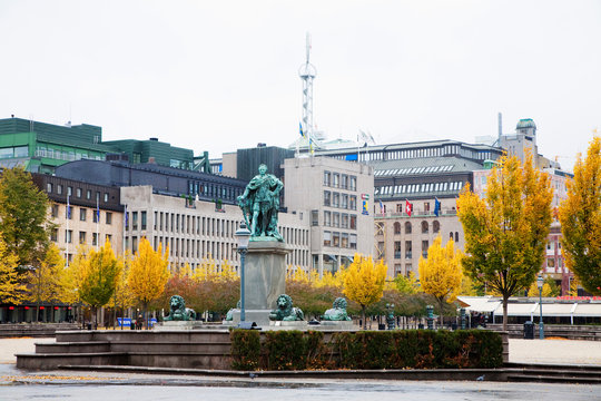 Stockholm, Sweden - A statue of a man surrounded by lions. In the background, a cityscape is viewable.