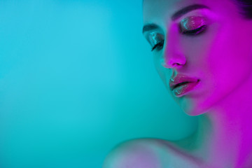 High Fashion model girl in neon lights posing in studio, portrait of beautiful woman, trendy glowing make-up. Art design colorful make up.