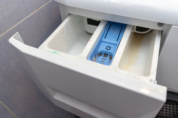Dirty moldy washing machine detergent and fabric conditioner dispenser drawer compartment close up....