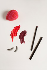 Beauty products and red lipstick smear