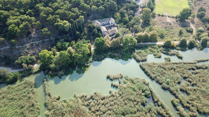 Aerial drone bird's eye panoramic photo of iconic city, castle and mosque of Ioanina surounded by famous lake and mountains of Pindus, Epirus, Greece