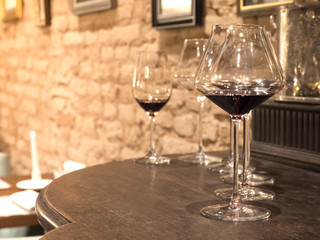 Glasses of vintage wine are on the bar. Toned