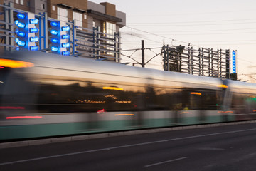 Light rail streaks past buildings creating blur