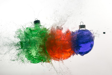 Stop action of Christmas ornaments filled with colored water and exploding form bullet impact.