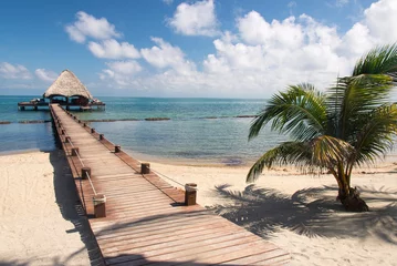 Photo sur Plexiglas Jetée Placencia, Belize. Roberts Grove Resort, Pier mène de la plage de sable au quai au toit de chaume utilisé comme bar de divertissement la nuit.