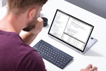 Man Programming Code On Laptop Computer