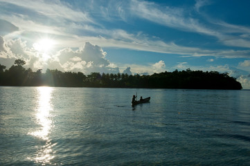 Boys in a canoe in backlight in the Marovo Lagoon, Solomon Islands, Pacific