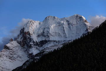 Chenrezig, holy snow mountain in Daocheng Yading Nature Reserve - Garze, Kham Tibetan Pilgrimage region of Sichuan Province China. Snow capped mountain Xiannairi - Dusk, Twilight Blue Sky