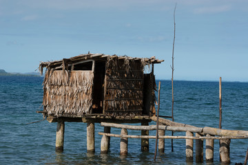 Melanesia, Papua New Guinea, Dobu Island. Typical island village over water outhouse.