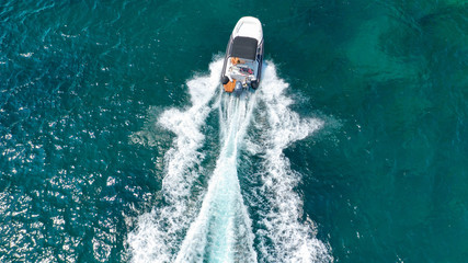 Aerial top view luxury inflatable rib speed boat cruising in Mediterranean emerald sea