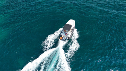 Aerial top view luxury inflatable rib speed boat cruising in Mediterranean emerald sea