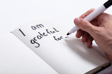 Person Writing I Am Grateful For Text