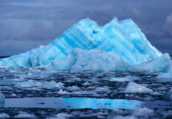 Chile, San Rafael Lagoon NP. An iceberg, striated blue and white, rises like a mountain from the...