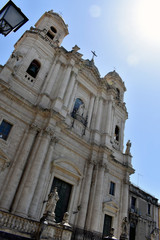 Upward view of the facade of the Catania baroque church of Saint Francis of Assisi to the Immaculate with bright sun and blue sky in the background