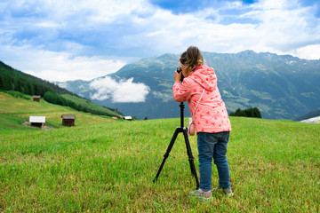 Little Girl Taking Photo Of Mountain Landscape