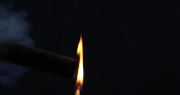 Close up of match lighting cigar profile.