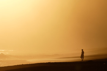 Fototapeta na wymiar Costa Rica, Osa Peninsula. A surfer studies the waves at sunset along the Osa Peninsula. 