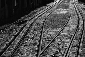 The tracks of the tramway of Lisbon on a black and white abstract composition with diagonal lines