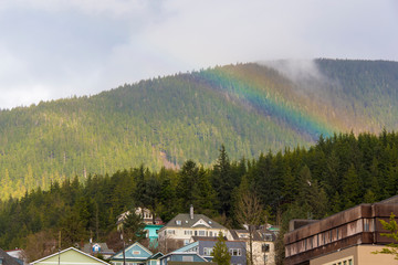 US, Alaska, Ketchikan. Rainbow seems to lay across hills behind town