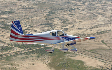 USA, Arizona, Red White and Blue Vans airplane flying over the desert