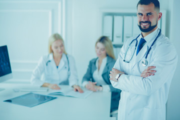 Happy doctor with medical staff at the hospital