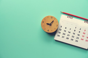 close up of calendar and alarm clock on the green table, planning for business meeting or travel...