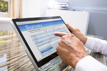 Man Filling Online Survey Form On Digital Tablet