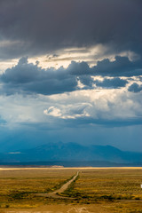 Dirt road and clouds over mountain