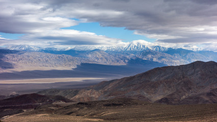 Fototapeta na wymiar Brown mountains and desert with snow capped peaks of Sierra Nevada Mountains