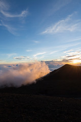 Sunset viewed from the top of Mauna Kea Volcano on the Big Island of Hawaii with lava rock in foreground
