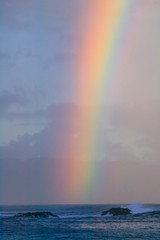 Vibrant rainbow offshore, Pacific storm waves, North Shore of Oahu, Hawaii