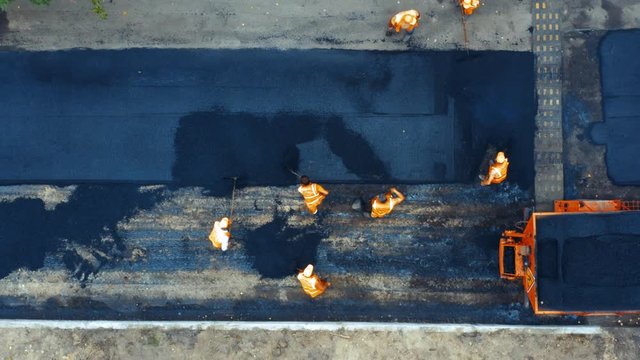 Aerial top view of roadworks with road workers lay asphalt 